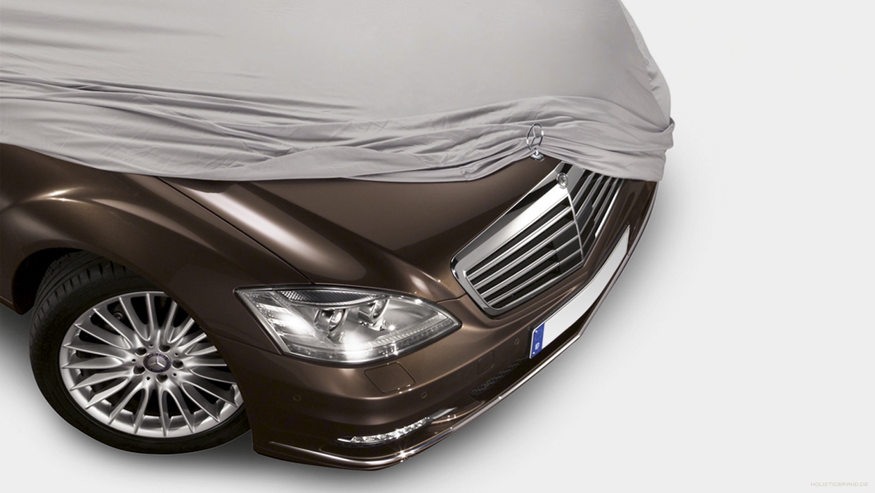 Fotografische Bildkomposition einer von einem Tuch halbenthüllten Mercedes-Benz-Motorhaube